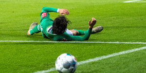 Fußballer rücklings auf dem Boden liegend