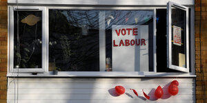 In einem Fester hängt ein Wahlplakat für Labour, darunter kaputte Luftballons