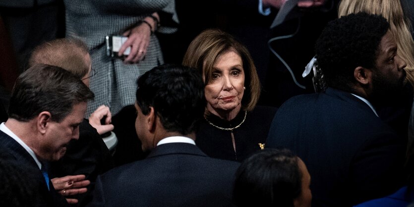 Ein paar Menschen stehen zusammen in der Mitte Nancy Pelosi