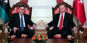zwei Männer vor der libyschen und türkischen Nationalflagge: Sarradsch und Erdoğan