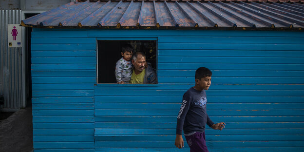 Ein Migrant mit seinem Sohn schaut aus dem Fenster