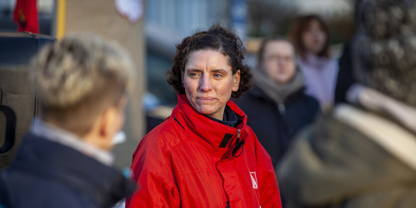 Eine dunkelhaarige Frau im roten Mantel