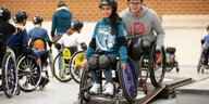 Eine junge Rollstuhlfahrerin passirt eine Rampe