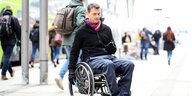 Mann im Rollstuhl auf Bahngleis