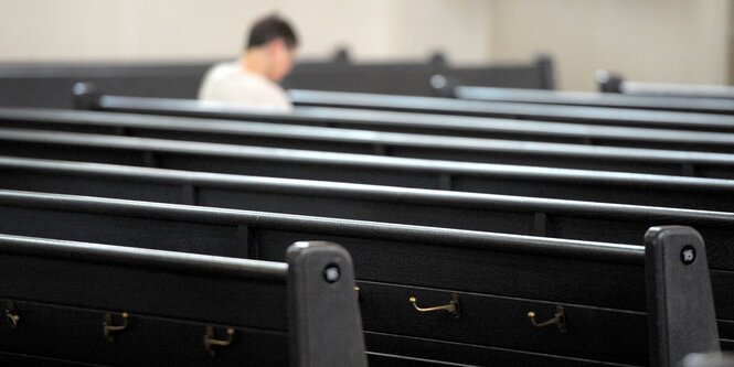 Mensch sitzt auf Kirchenbank