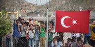 Kinder hinter Stacheldraht, an dem eine türkische Fahne hängt