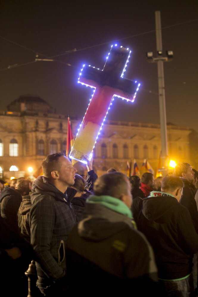 Ein Jesus-Kreuz leuchtet in schwarz-rot-gold auf der Pegida-Demo in Dresden im Oktober 2015.