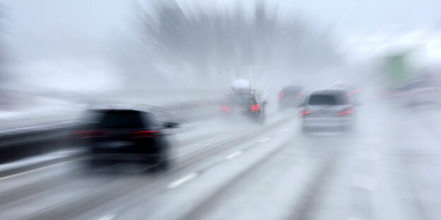 Autos fahren mit hoher Geschwindigkeit auf einer winterlichen Autobahn.