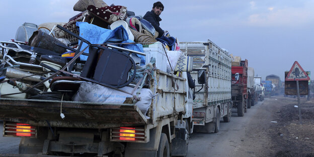 Mann auf einem voll beladen Lastwagen auf der Flucht vor einer Militäroffensive in Idlib