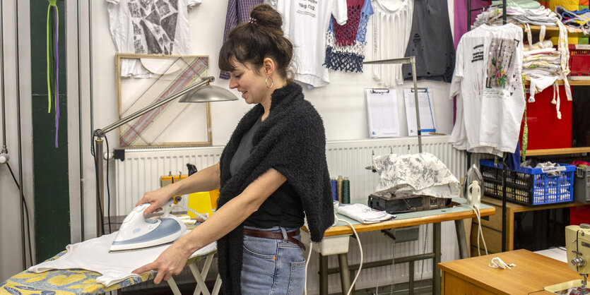 Upcycling in der Berliner Stadtmission - Frau am Bügelbrett