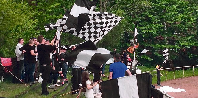 Fans des „Anhängerclubs ASV Bergedorf 85“ stehen im Stadion und schwenken Fahnen.