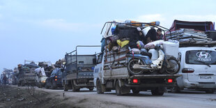 Ein Konvoi voll bepackter Autos in der Dämmerung auf der Straße