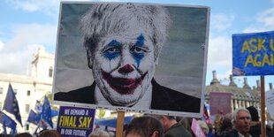 Boris Johnson auf einem Demo-transparent, geschminkt wie der Joker