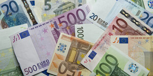Zahlreiche Euro-Banknoten liegen auf einem Haufen.