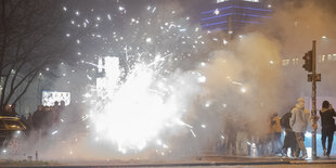 Feinstaub zu Silvester in Berlin: Böller und Raketen steigen auf der Straße an der Oberbaumbrücke in die Luft - man sieht viel Staub in der Luft