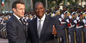 Macron neben Ouattara, dahinter eine Reihe von Männern in Uniform