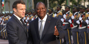 Macron neben Ouattara, dahinter eine Reihe von Männern in Uniform