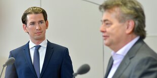 Kurz und Kogler bei einer Pressekonferenz. Kogler unscharf im Vordergrund, Bildfokus auf Kurz.