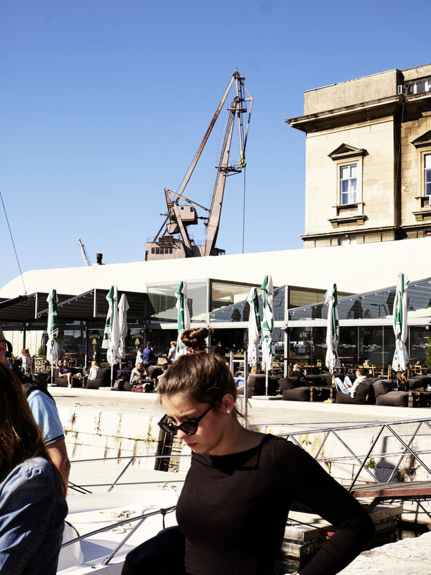 Frau vor einem Cafe am Hafen Frau vor einem Cafe am Hafen