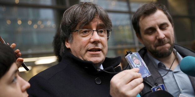 Carles Puigdemont vor zeigt vor dem Europäischen Parlament Journalisten seinen Ausweis.
