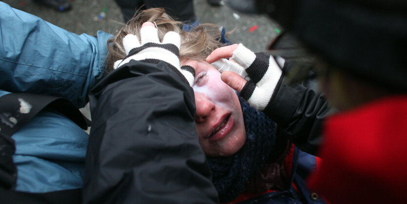 Eine Frau bekommt die Augen ausgespült