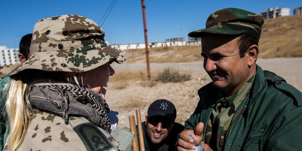 Eine Bundeswehrsoldatin steht einem kurdischen Soldaten gegenüber