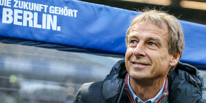 Winterpause bei Hertha: Jürgend Klinsmann grinst vor der Hertha-Bank