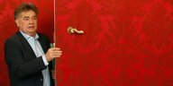 Ein Mann guckt steht in einer roten Tür