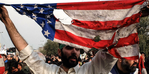 Ein Demonstrant hält eine zerissene US-Flagge in die Höhe