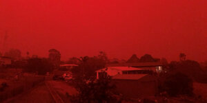 Häuser unter einem glühend roten Himmel