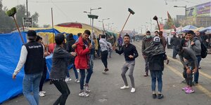 Mitte dezember demonstrieren Menschen gegen die Regierung von Irak auf dem Tahrir-Platz in Bagdad. Sie tanzen und heben dabei lange Besen in die Luft.