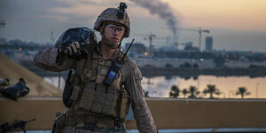 Ein US-Soldat in Bagdad trägt einen Sandsack auf der Schulter.
