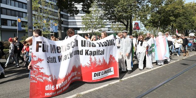 DemonstrantInnen halten ein Transparent mit der Aufschrift: "Für Mensch und Natur statt Markt und Kapital. Die Linke."