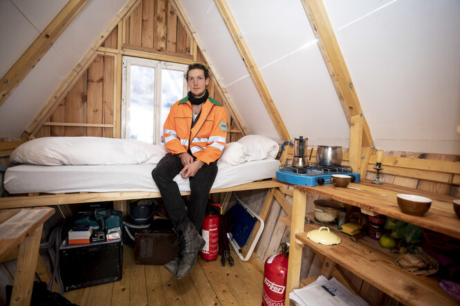 Ein Mann sitzt in einem kleinen Haus