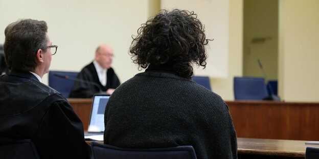Ein Angeklagter und sein Verteidiger sitzen im Gerichtssaal