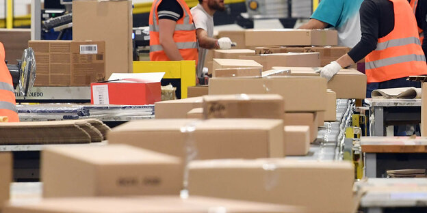 Im Amazon Logistikzentrum Pforzheim laufen Pakete auf einem Band zum Versand.
