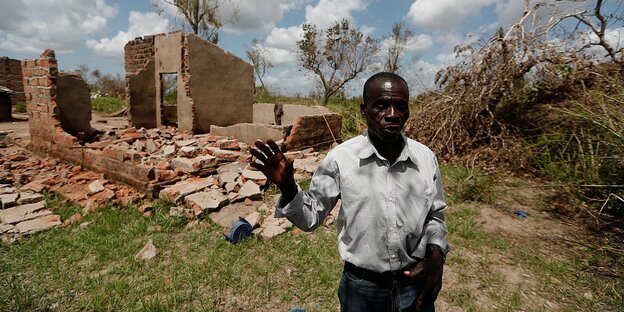 ein Mann steht vor seinem zerstörten Haus