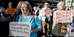 Zwei Frauen protestieren in Berlin gegen die angekündigte Schließung des Discounters Aldi. Auf ihren Schildern steht "Ernährungswende muss sozial sein, sonst ist sie keine" und "Wo kaufst du ein, wenn Aldi weg ist?!"