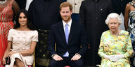 Meghan Harry und die Queen sitzen auf Stühlen