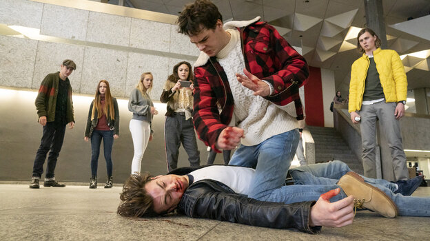 Ein Schüler kniet auf einem anderen, beide bluten