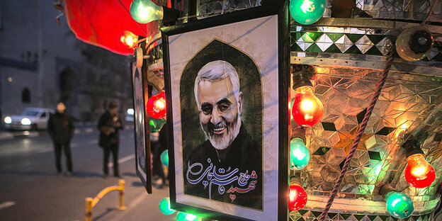Bunte Lampen umrahmen ein Bild von General Soleimani