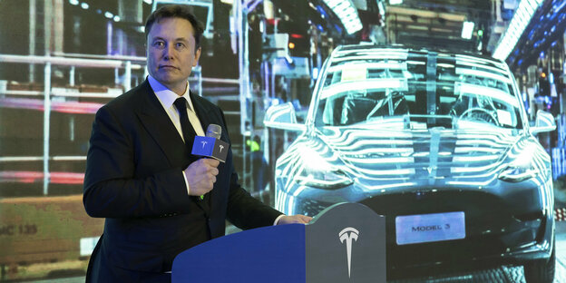 Tesla-Gründer Elon Musk steht vor einem Tesla Model 3 in der neuen Fabrik in Shanghai