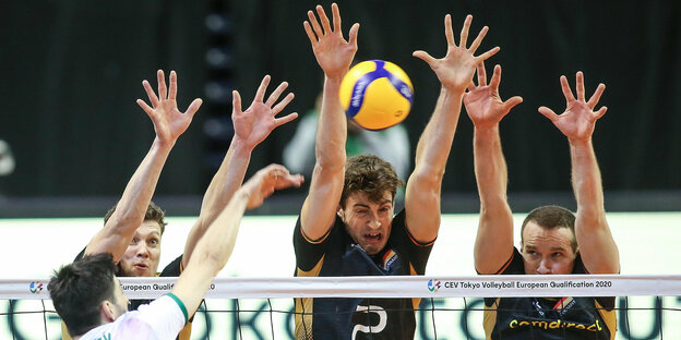 Volleyballspieler strecken die Hände nach oben