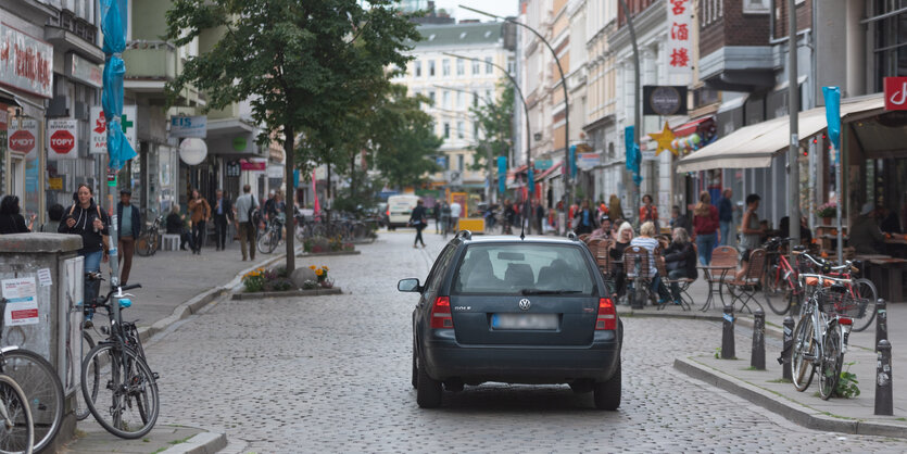 Ein Auto ist von hinten zu sehen, es fährt durch eine Straße, in der eigentlich keine Autos fahren dürfen