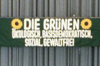 Transparent mit Sonnenblumen und der Aufschrift "Die Grünen - ökologisch, basisdemokratisch, sozial, gewaltfrei"