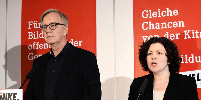 Die Fraktionsvorsitzenden der Partei DIE LINKE im Bundestag, Amira Mohamed Ali und Dietmar Bartsch stehen vor einem roten Banner der Linken.