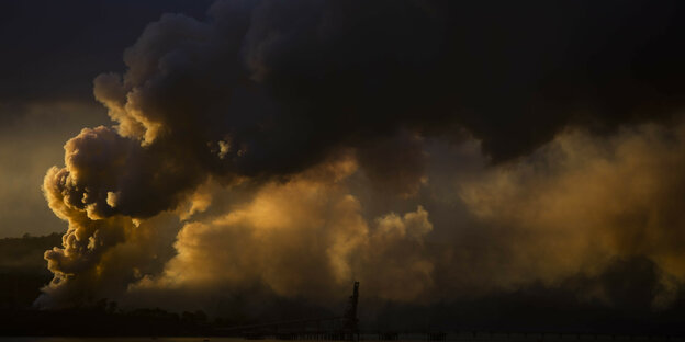 Dicke dunkle Rauchschwaden steigen über Landschaft in Eden, Australien, auf.