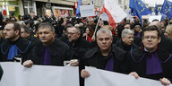 Richter und Rechtsanwälte aus ganz Europa, viele von ihnen in ihren Richterroben gekleidet, marschieren schweigend durch Warschau