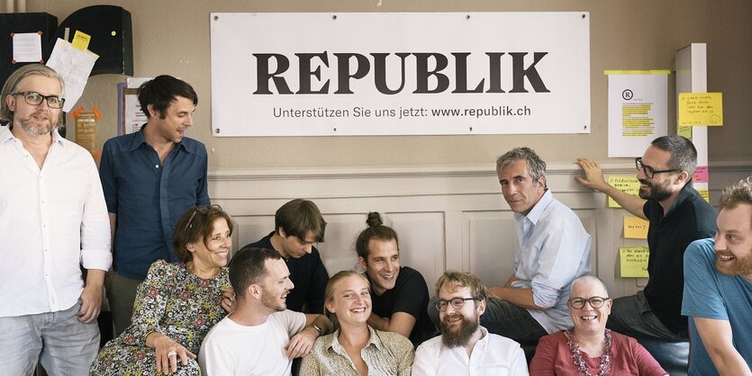 Menschen sitzen unter dem Schriftzug des Magzins "Republik" und blicken in die Kamera