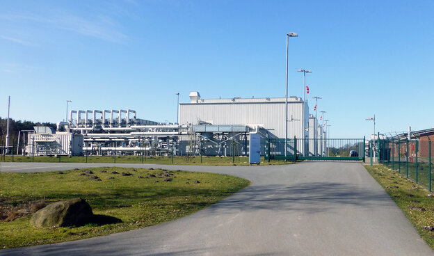 Umzäunte Hallen stehen auf der grünen Wiese